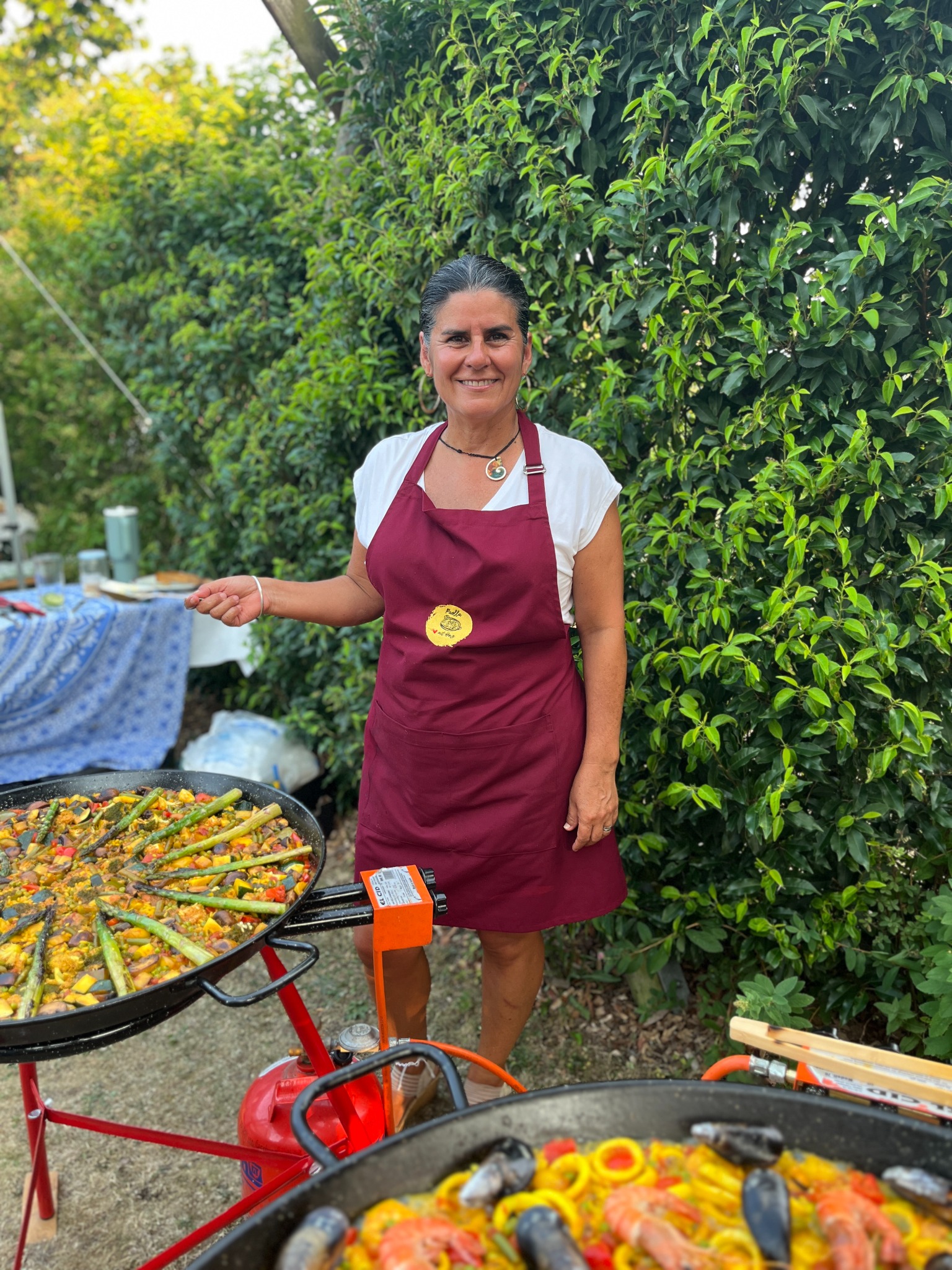 Carla beim Live Cooking mit mehreren Paella-Pfannen