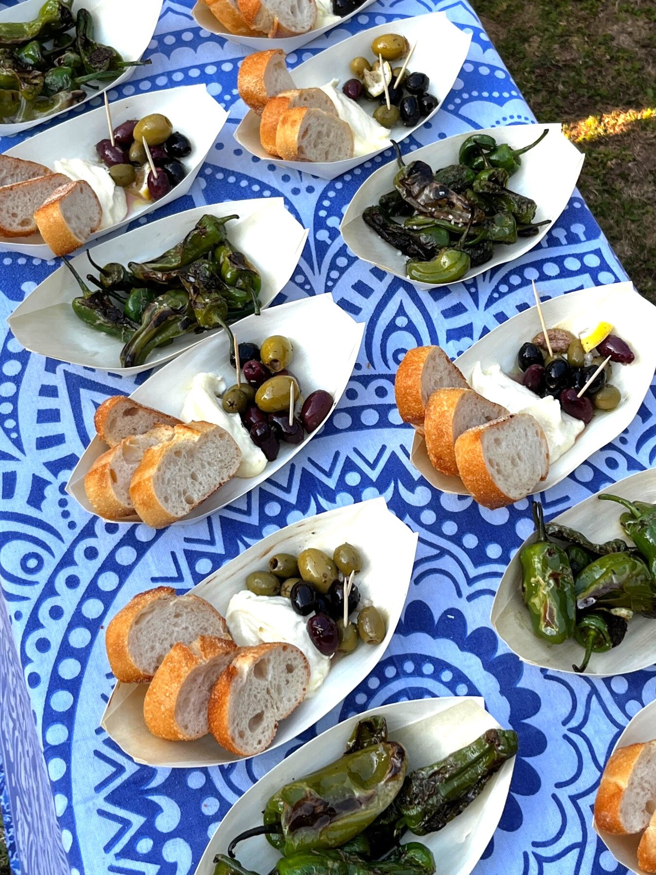 Pimientos, Alioli, Oliven und Baguette auf spanischen Tapas-Tellern